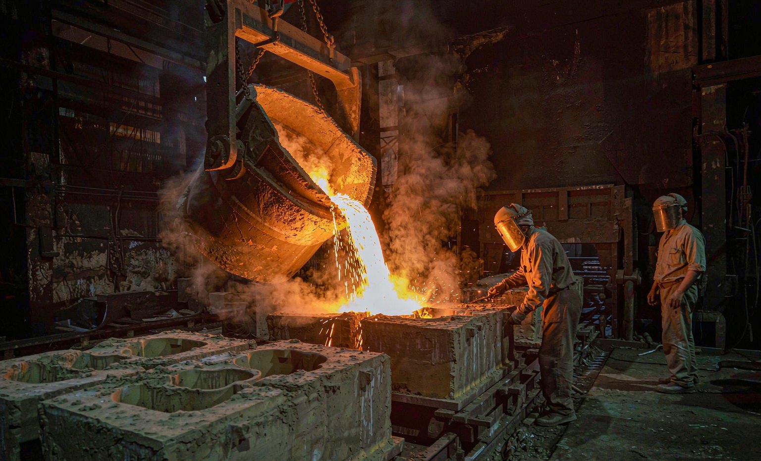 Molten metal poured into sand moulds for valve body castings